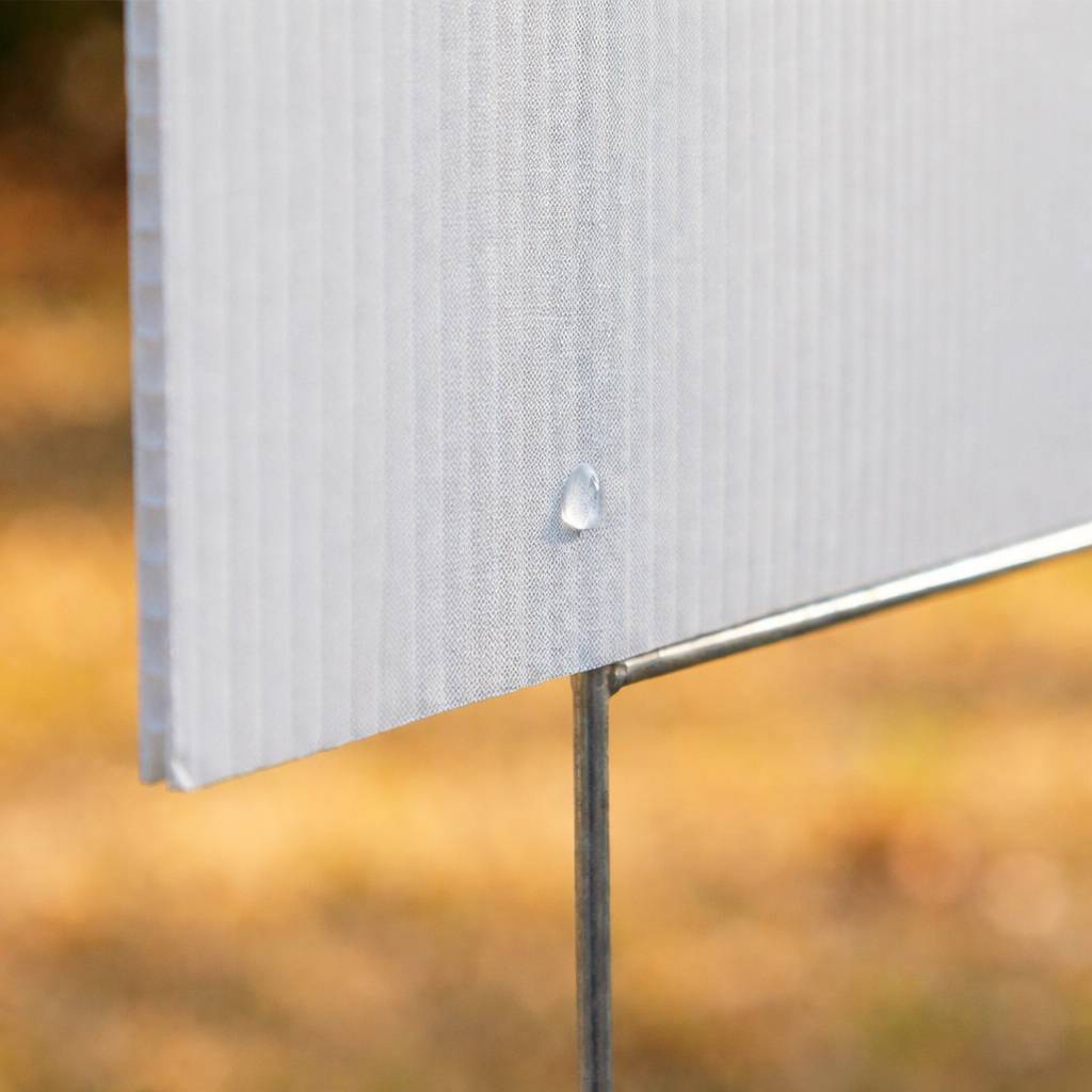 Close-up detail of a corrugated plastic yard sign (Coroplast) and its metal H-stake, showing its durability.