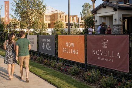 Custom fence banners advertising new homes model homes and a residential development under construction
