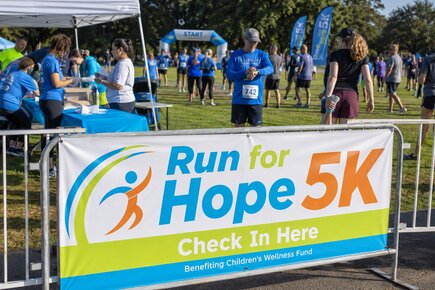 Custom event vinyl banner for the Run for Hope 5K displayed at an outdoor race check in area