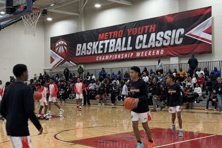 Large custom sports vinyl banner for the Metro Youth Basketball Classic displayed inside a packed gymnasium