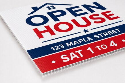 Close up view of a stack of printed real estate yard signs showing the durable 4mm corrugated plastic texture on a custom open house sign